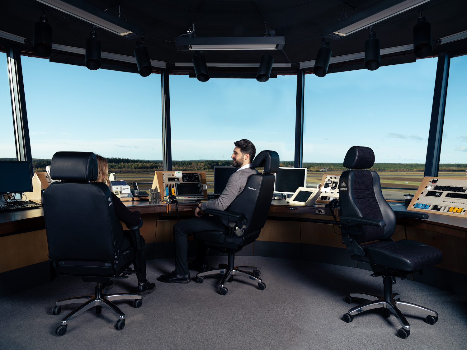 People sitting in RH Secur24 24/7 chairs in a control tower